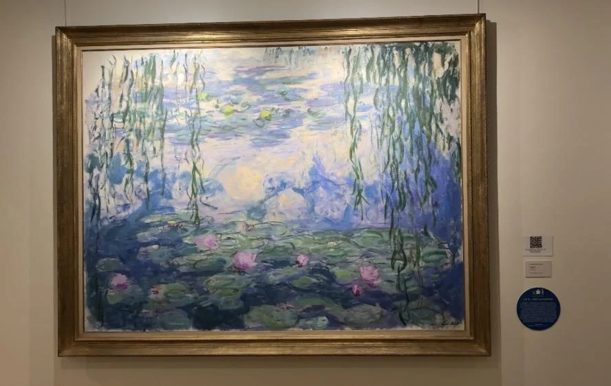 Claude Monet’s Water Lilies painting hanging in a gilded frame on a gallery wall